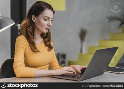 side view woman working laptop