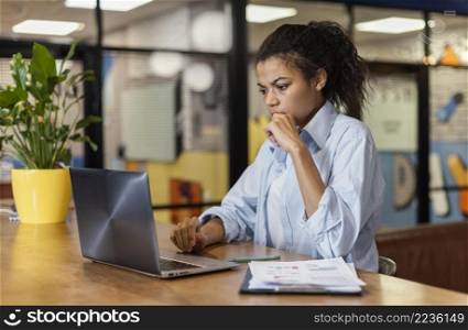 side view woman working office with laptop