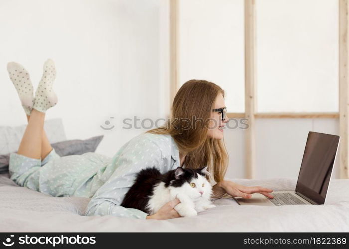 side view woman working pajamas from home with cat