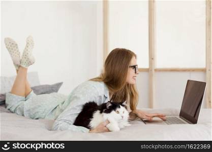 side view woman working pajamas from home with cat