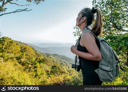 Side view Young asian hiking female standing at view point and looking beautiful view with happy on peak mountain and sunray,  copy space