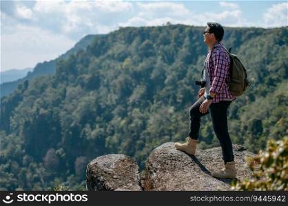 Side view, young asian hiking man standing and rise-up hands with happy on peak of rocky mountain, beautiful landscape in background, copy space