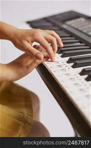 side view young girl learning how play electronic keyboard