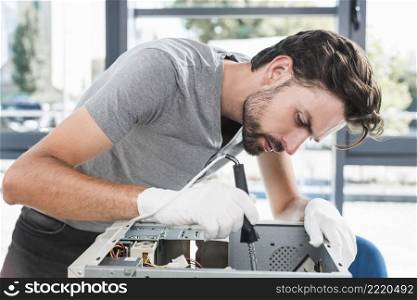 side view young male technician working broken computer
