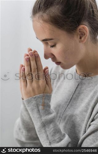 side view young woman praying home