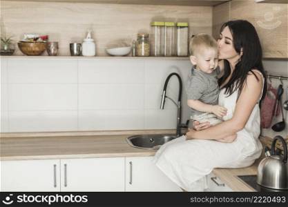 side view young woman sitting kitchen counter loving her son
