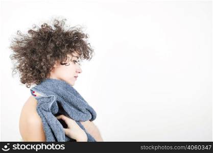side view young woman with curly hair wipes her body with towel against white background