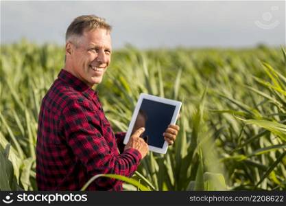 sideview man with tablet maize field mock up