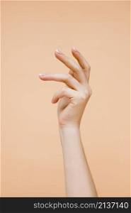 sideview woman s hand pale orange background
