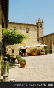 Sidewalk cafe beside a church, Romanesque Church, Piazza Roma, Monteriggioni, Siena Province, Tuscany, Italy