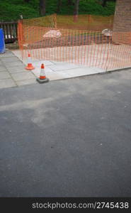 sidewalk construction site with orange cones and delimitation area