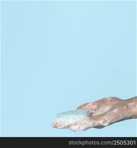 sideways person holding blue soap with copy space