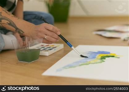 sideways person sitting floor paints