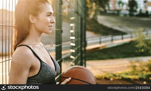 sideways woman playing basketball alone