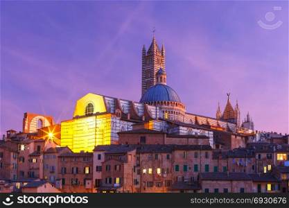 Siena Cathedral at night, Tuscany, Italy. Beautiful view of Dome and campanile of Siena Cathedral, Duomo di Siena, and Old Town of medieval city of Siena during evening blue hour, Tuscany, Italy