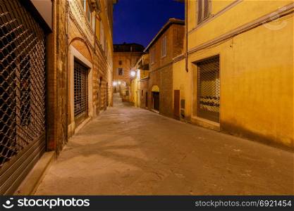 Siena. Old city street at night.. An old traditional street with a cobblestone street at night. Siena. Tuscany. Italy.