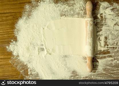Sifted flour and rolling pin on the table. Kitchen background