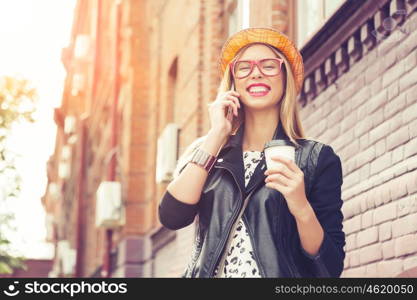 Sightseeing in touristic city. Happy tourist girl with coffee cup walking on city street