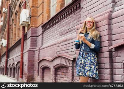 Sightseeing in touristic city. Happy tourist girl with coffee cup walking on city street