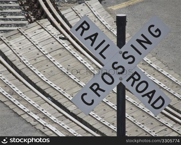 sign indicating a railroad crossing with the tracks in the background