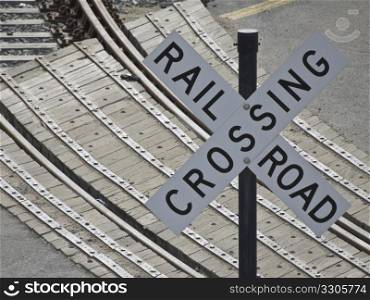 sign indicating a railroad crossing with the tracks in the background
