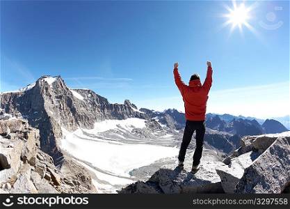 Sign of victory: climber on the top of the mountain. Gran Paradiso National Park, Italy