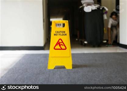 Sign showing warning of caution wet floor, cleaner on the background yellow. Sign showing warning of caution wet floor, cleaner on the background