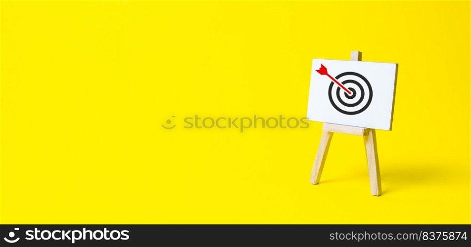 Sign stand with an arrow in the target on a yellow background. Hit exactly on center. Tactics of advertising targeting. advertise c&aigns. Goal Achievement and Purposefulness