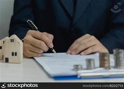 Sign the house approval document. Real estate appraisal, buy and sell houses, business concept finance.businessman holding pen and signing documents at desk
