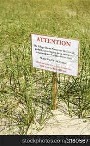 Sign warning visitors not to walk on or disturb natural dune area.