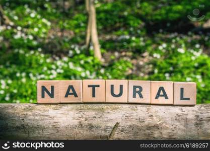 Sign with the word natural in a green forest