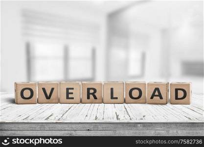 Sign with the word overload in a bright office environment on a wooden table