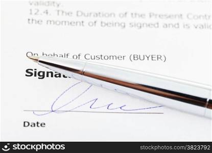 signature of sales agreement and silver pen close up