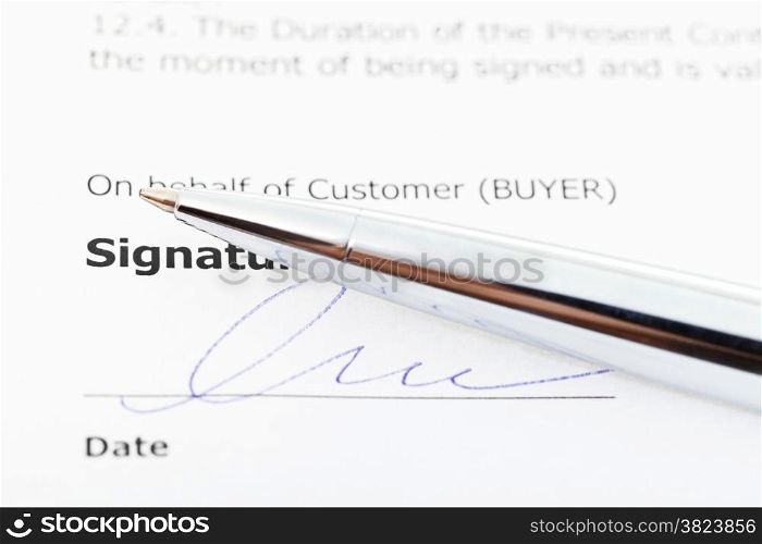 signed sales contract and silver pen close up