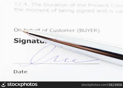 signed sales contract and silver pen close up