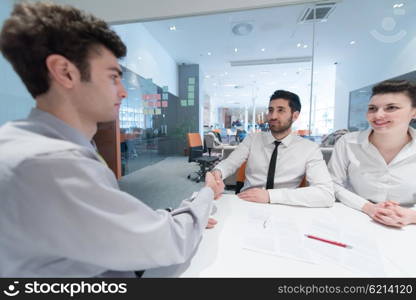 signing contract on partners back, young couple on business meeting with life insurance and bank loan agent at modern office interior