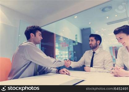 signing contract on partners back, young couple on business meeting with life insurance and bank loan agent at modern office interior