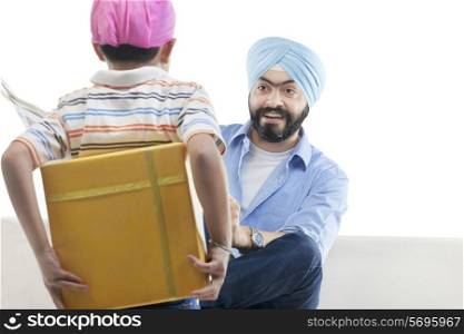 Sikh boy hiding a gift from his father