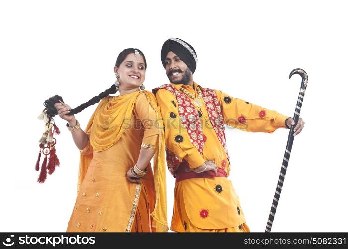 Sikh couple standing back to back