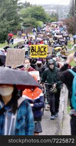 Silent protesters march in the rain through neighborhoods in Seattle calling attention to the Black Lives Matter Movement and Police Brutality