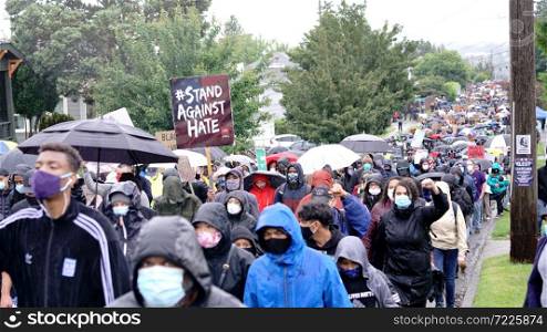 Silent protesters march in the rain through neighborhoods in Seattle calling attention to the Black Lives Matter Movement and Police Brutality