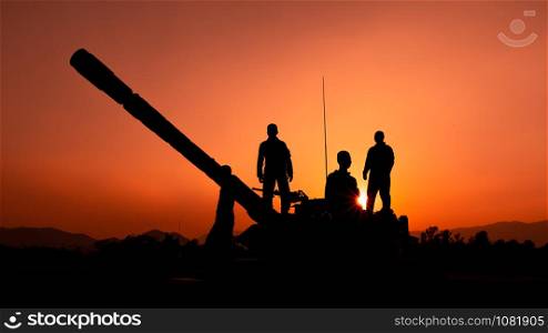 silhouette and over the sunrise background cannon soldiers team standing holding gun in Thailand