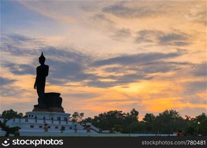 silhouette big buddha statue in sunset. reflection on the water in sunset