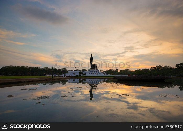 silhouette big buddha statue in sunset. reflection on the water in sunset