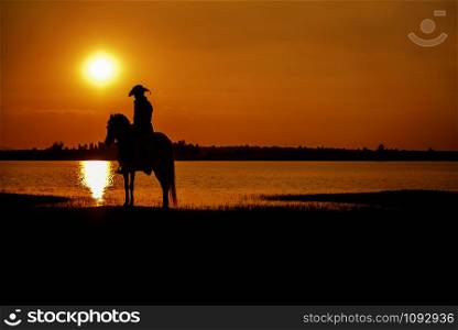 silhouette cowboy on horseback during nice sunset landscape background. silhouette cowboy on horseback