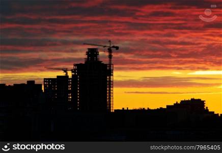 silhouette crane on building at sunset