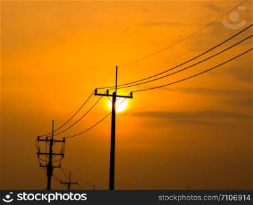 Silhouette electric pole at sunset, Thailand