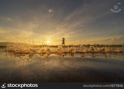 Silhouette Fisherman casting or throwing a net for catching freshwater fish in nature lake or river with reflection in morning time in Asia in Thailand. People.