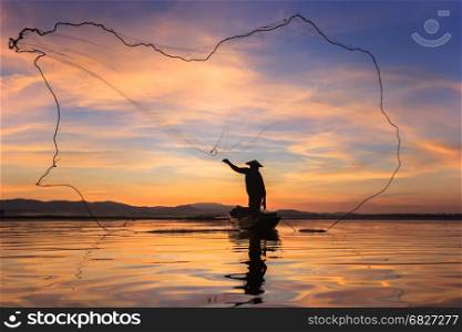Silhouette fisherman on fishing boat setting net with sunrise