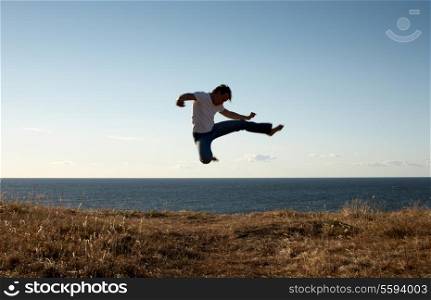 silhouette image of martial arts master jump-kicking